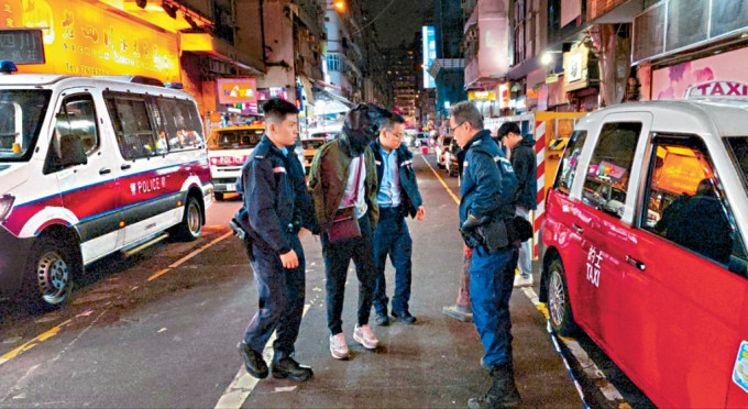 涉案的士司机被黑布蒙头由警员押走。