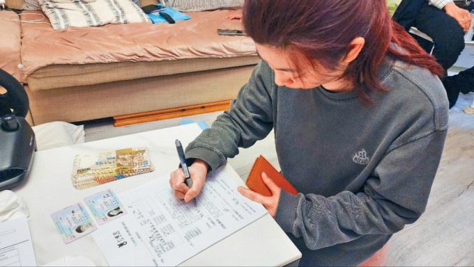 元朗公路7車「串燒」車禍死者王元亨的遺孀，簽收「仁間有愛應急錢計劃」捐款。